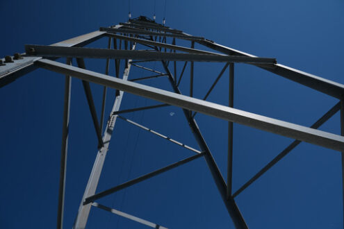 Pylon. High voltage power line pylon on blue sky background. - MyVideoimage.com | Foto stock & Video footage