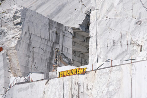 Quarry wall. White Henraux marble quarry in the Apuan Alps. Volvo excavator. - MyVideoimage.com | Foto stock & Video footage