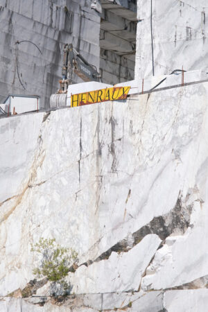 Quarry wall. White Henraux marble quarry in the Apuan Alps. Volvo excavator. - MyVideoimage.com | Foto stock & Video footage