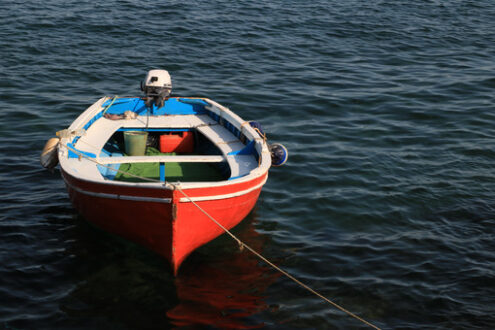 Red-colored boat anchored at the sea port. A small fishing boat. - MyVideoimage.com