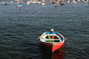 Red-colored boat anchored at the sea port. A small fishing boat. - MyVideoimage.com