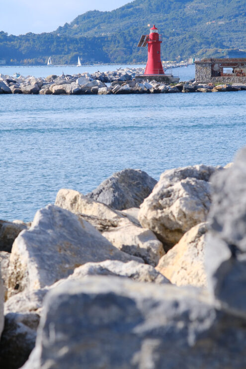 Red lighthouse on the rocks at the entrance to the port of La Spezia. - MyVideoimage.com | Foto stock & Video footage