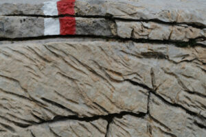 Red mark on the stone. Stone carved from water erosion with a red and white trail mark. Stock photos. - MyVideoimage.com | Foto stock & Video footage