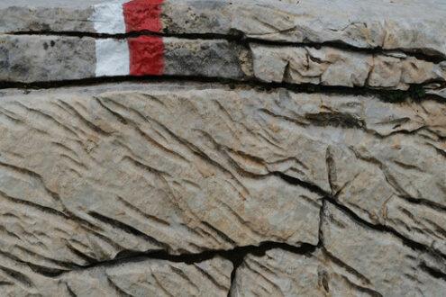 Red mark on the stone. Stone carved from water erosion with a red and white trail mark. Stock photos. - MyVideoimage.com | Foto stock & Video footage