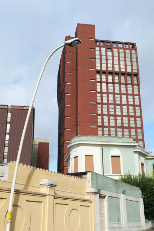 Red skyscraper. Skyscraper covered with safety net. Stock photos. - MyVideoimage.com | Foto stock & Video footage