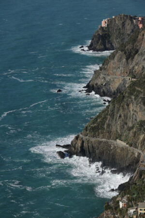 Riomaggiore sea. Panorama of the village of Riomaggiore in the Cinque Terre. Rough sea with waves on the cliff. Foto sfondo mare. - MyVideoimage.com | Foto stock & Video footage