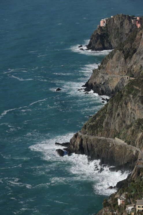 Riomaggiore sea. Panorama of the village of Riomaggiore in the Cinque Terre. Rough sea with waves on the cliff. Foto sfondo mare. - MyVideoimage.com | Foto stock & Video footage