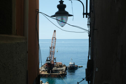 Riomaggiore, street lamp and barge with crane for dredging the seabed at the port, Cinque Terre, royalty free - MyVideoimage.com | Foto stock & Video footage