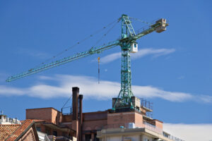 Ristrutturazione edificio a Milano. Construction crane mounted on the roof of a building in Milan. Cantieri edili. - MyVideoimage.com | Foto stock & Video footage