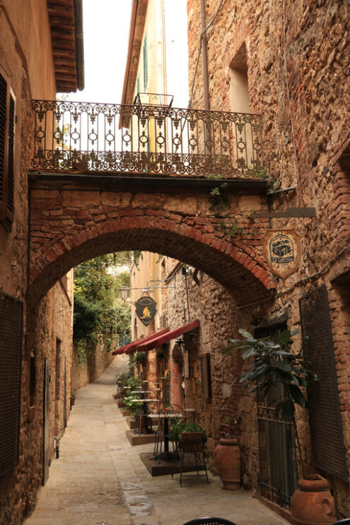 Romantic restaurants in a street of Massa Marittima. An alley with restaurant signs and tables with chairs. - MyVideoimage.com | Foto stock & Video footage