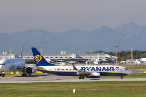 Ryanair Boeing 737-800 airplane on the Malpensa airport runway. Behind Easyjet Airbus airplane lands on the Malpensa airport runway. - MyVideoimage.com