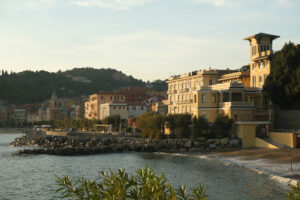 San Terenzo beach. Sea village of San Terenzo of Lerici. Houses and church near the sea with people on the beach and rocks. - MyVideoimage.com | Foto stock & Video footage