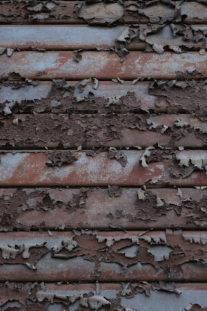 Saracinesca arruginita. Peeled paint on a rusty shutter. This photo shows the paint peeling off the iron slats of a shutter. - MyVideoimage.com | Foto stock & Video footage