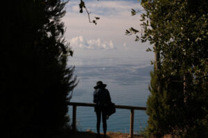 Seascape with tourist in Cinque Terre. Tourist admires the marine landscape of the Cinque Terre in Liguria. - MyVideoimage.com | Foto stock & Video footage