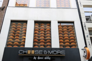 Shop showcase with large cheeses on display. Shop signboard. - MyVideoimage.com