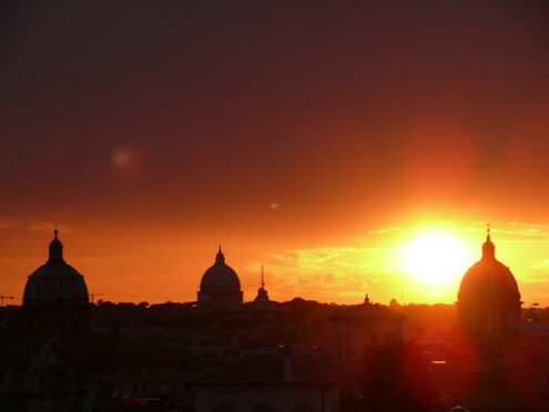 Skyline di Roma con sole al tramonto. Skyline with the setting sun over Rome’s rooftops seen from the Caffarelli terrace. Church domes and city profile. - MyVideoimage.com | Foto stock & Video footage