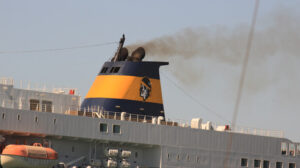 Smokestack of a large ship in the harbor. Black smoke comes from - MyVideoimage.com