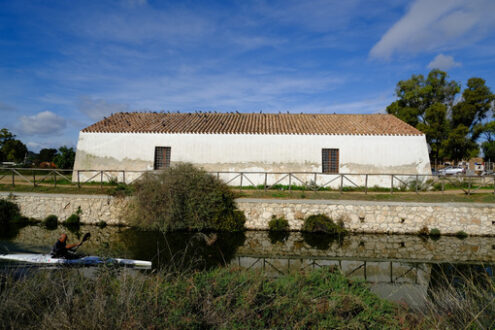 Sportsman on canoe. Farmhouse near the canal in the Cagliari lagoon. Stock photos. - MyVideoimage.com | Foto stock & Video footage