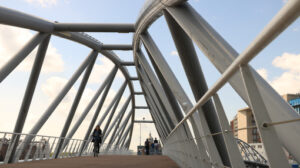 Steel pedestrian bridge over a canal in Amsterdam. A tourist boa - MyVideoimage.com