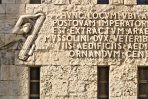 Stone engraving. Written from the fascist era engraved on stone in the facade of the building. - MyVideoimage.com | Foto stock & Video footage