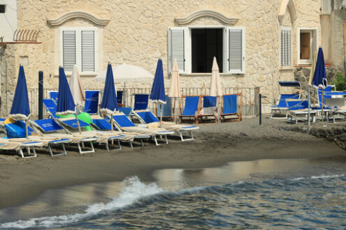 Stone house on the beach of the Mediterranean sea. Umbrellas and - MyVideoimage.com