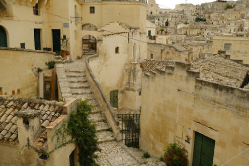 Strada di paese a Matera. Stairway in a street of the ancient city of Matera. Beige stone paving and houses in tuff blocks. - MyVideoimage.com | Foto stock & Video footage