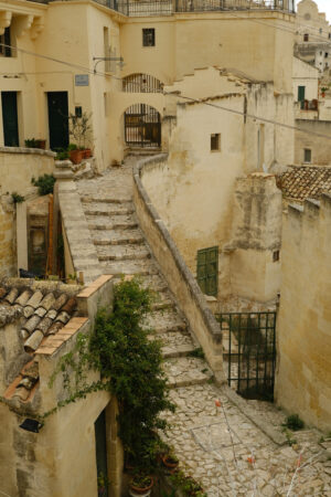 Strada di paese a Matera. Stairway in a street of the ancient city of Matera. Beige stone paving and houses in tuff blocks. - MyVideoimage.com | Foto stock & Video footage