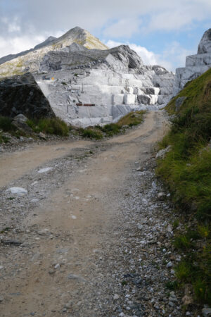 Strada sterrata sulle Alpi Apuane. White road leads to a marble quarry on the Apuan Alps in Tuscany.  Foto stock royalty free. - MyVideoimage.com | Foto stock & Video footage