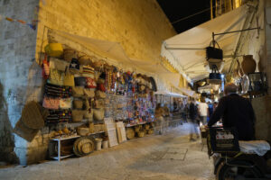 Street in the historic center of Bari with market for tourists. Bags and souvenirs in an alley with night lights. - MyVideoimage.com | Foto stock & Video footage