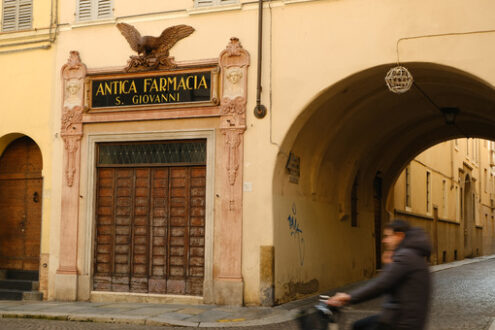 Street with arch and pharmacy shop with ancient sign with eagle. - MyVideoimage.com