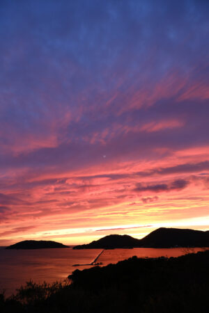 Sun setting over the sea with red and blue clouds. Gulf of La Spezia, Mediterranean Sea in Liguria. - MyVideoimage.com | Foto stock & Video footage