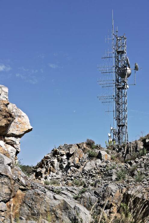 Telecommunication antennas. Trellis with numerous transmitting antennas installed on a rocky mountain. - MyVideoimage.com | Foto stock & Video footage