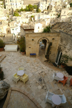 Terraces of hotels in Matera. Roofs of houses in the Sassi of Matera transformed into hotels. Panoramic terrace with sofa and chair in white plastic. - MyVideoimage.com | Foto stock & Video footage