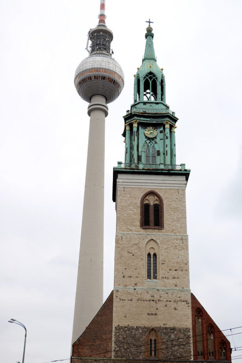 The Alexanderplatz TV tower next to the bell tower of a historic - MyVideoimage.com