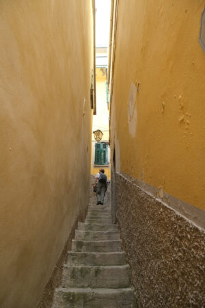 Tourist in the Cinque Terre. Tourist climbs a steep staircase in a narrow alley in the center of the village. - MyVideoimage.com | Foto stock & Video footage