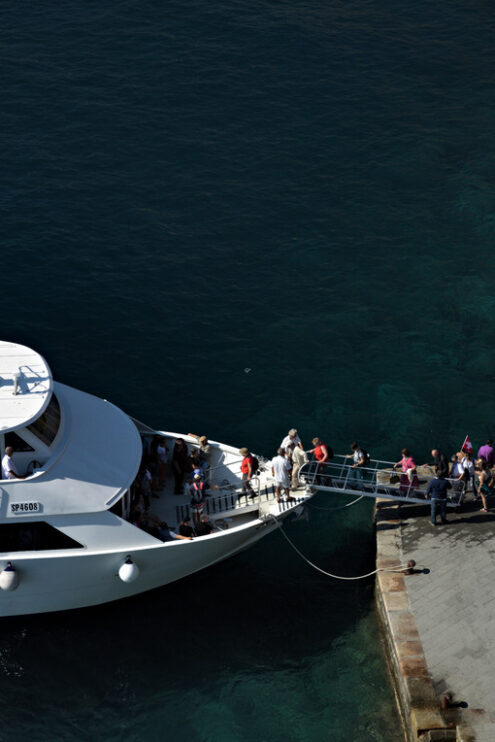 Tourists Cinque Terre. Boat with tourists who disembark in Vernazza,  Cinque Terre village. Disembarkation of tourists in the deep blue sea - MyVideoimage.com | Foto stock & Video footage