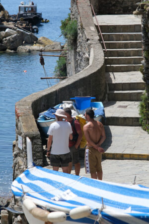 Tourists on the trail. Tourists with rucksacks stopped for a stop in front of the sea in the town square. In the background the path with stairs. - MyVideoimage.com | Foto stock & Video footage