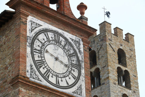 Towers with bell tower and large clock at the church of Impruneta, near Florence. Bell towers in terracotta and stone bricks. - MyVideoimage.com