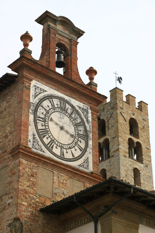 Towers with bell tower and large clock at the church of Impruneta, near Florence. Bell towers in terracotta and stone bricks. - MyVideoimage.com