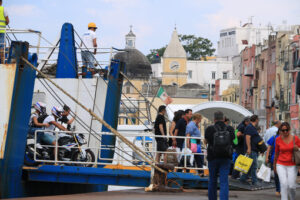 Traghetto Procida. Ferry boat  at the port of Procida, Naples. Docking stage at the pier. People intent on landing. - MyVideoimage.com | Foto stock & Video footage