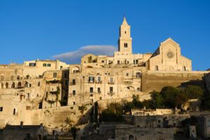 Tuff blocks in Matera. Houses, church and bell tower in the city of Matera in Italy. The tuff blocks are the material used for the construction of the houses. - MyVideoimage.com | Foto stock & Video footage