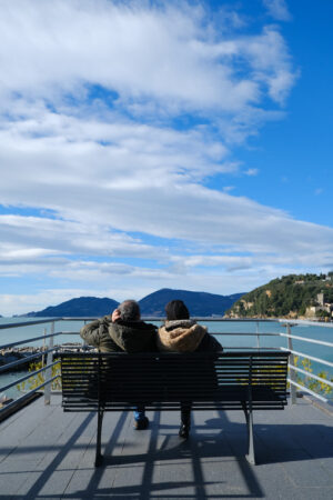 Two people sitting on a bench on a terrace overlooking the Lerici sea in Liguria. - MyVideoimage.com | Foto stock & Video footage