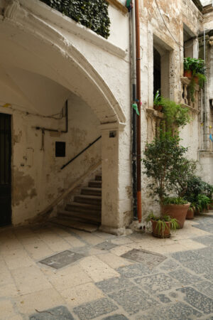 Typical Mediterranean house in an alleyway in the city of Bari. Facade painted white and climbing green plants. Foto Bari photo.