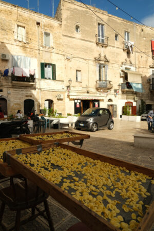 Typical Mediterranean pasta Orecchiette made to dry. Ancient houses in the alleys of the city of Bari. - MyVideoimage.com