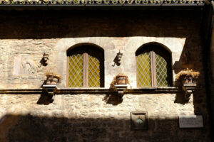 Typical windows in the facade of an ancient Italian house in Assisi. Decorate with flower vases. - MyVideoimage.com