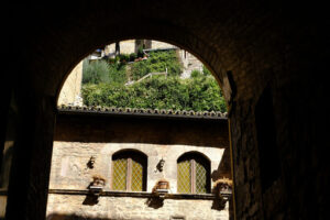 Typical windows in the facade of an ancient Italian house in Assisi. Decorate with flower vases. - MyVideoimage.com