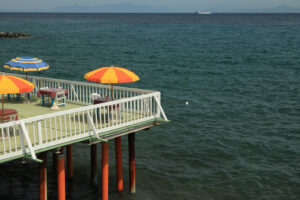 Umbrella on a pier with a white parapet on the sea of Ischia. In - MyVideoimage.com