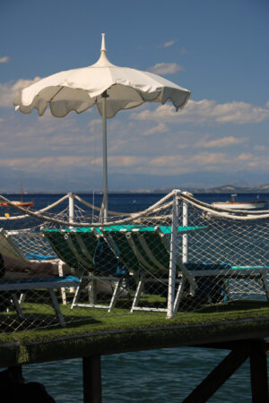 Umbrella on a pier with a white parapet on the sea of Ischia. In - MyVideoimage.com