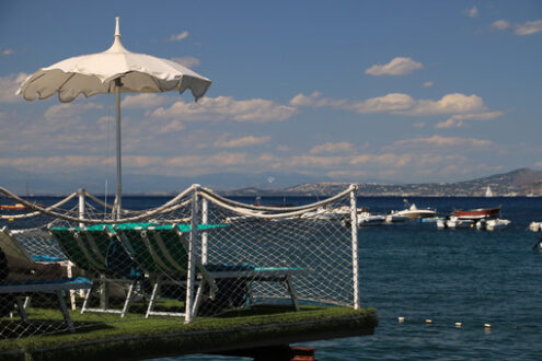 Umbrella on a pier with a white parapet on the sea of Ischia. In - MyVideoimage.com