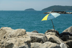 Umbrella on the cliff an boats. Colorful beach umbrella on the cliff. Stock photos. - MyVideoimage.com | Foto stock & Video footage